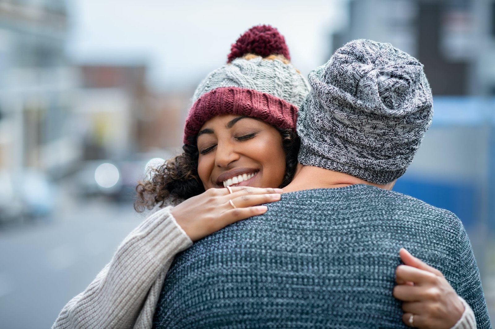 Multiethnic couple hugging outdoor in winter
