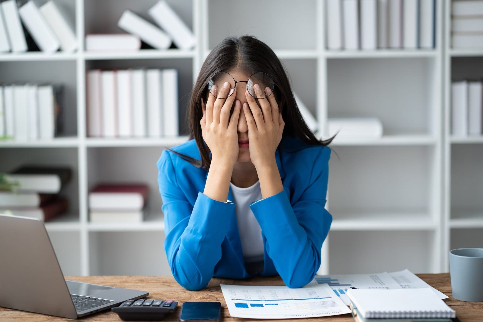 Stressed puzzled Asain businesswoman sitting in office room, burnout, overworked concept.